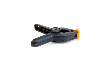 Black plastic clamp isolated on white background. Clamping equipment for handicraft, joinery and photography