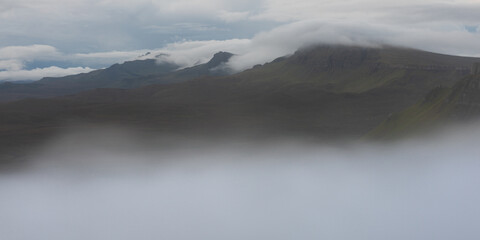 Fog rolling over mountains on the Trotternish Ridge, Isle of Skye, UK. Beautiful Scottish Highlands.