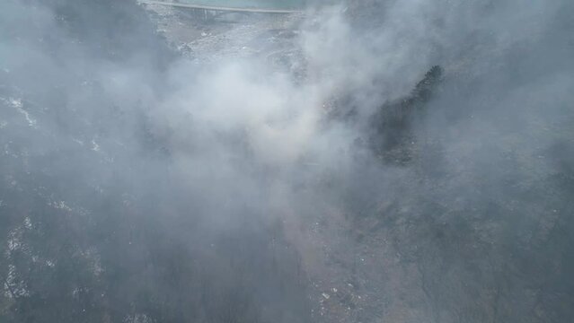 Aerial drone view of large garbage landfill, burning trash with loth of polluting smoke. 