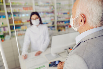 A senior man in pharmacy store getting medicines.