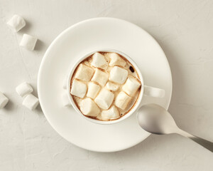 Cup of coffee with marshmallows on a white table. View from above