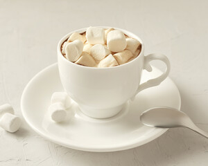 Cup of coffee with marshmallows on a white table