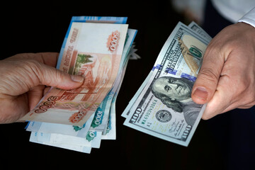 dollars and rubles. concept of currency exchange. Hands holding russian rouble and us dollar bills.