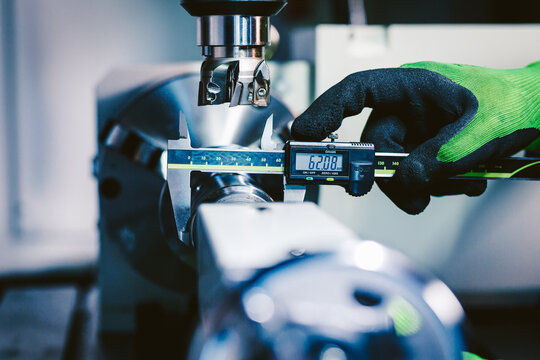 Quality control manufacturing.Hands of an engineer measures a metal part with a digital vernier caliper