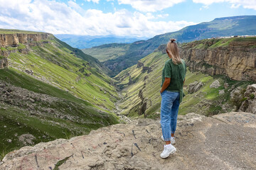 Fototapeta premium A girl on the background of the Khunzakh valley, Khunzakh waterfalls, Dagestan 2021