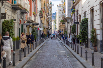 Fototapeta premium narrow European city road with a car driving away
