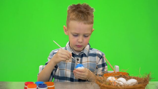 5 year old boy painting Easter eggs, chromakey