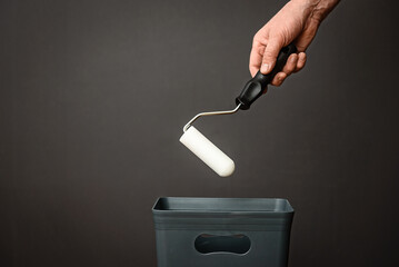 The roller paint brush is thrown into the bucket. The concept of recycling and recycling of garbage.