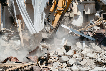 Close-up of excavator bucket raking in industrial debris. Demolishing of old dilapidated house for...