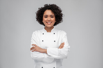 cooking, culinary and people concept - happy smiling female chef in white jacket over grey background - 488557897