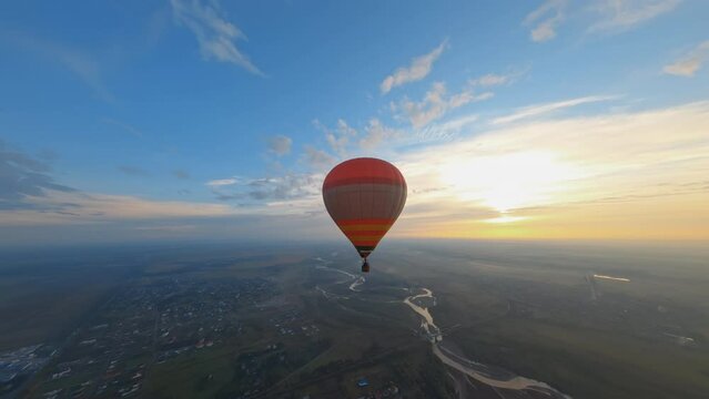 Birdseye view of beautiful colorful hot air balloon floating in picturesque evening sunset sky. Vacation. Travel destinations. Aerial scenery.
