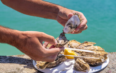 Man ready to eat a tray of fresh oysters outdoor.