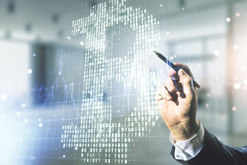 Double exposure of male hand with pen working with creative Bitcoin symbol hologram on blurred office background. Mining and blockchain concept