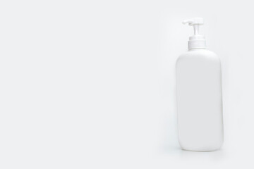 Healthcare, medical and personal hygiene treatment concept. Closeup of blank plastic bottle of nasal spray with selective focus isolated on abstract blurred white background. Runny nose. Snuffle.