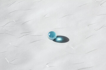 Clear glass bead reflect light on the white background.