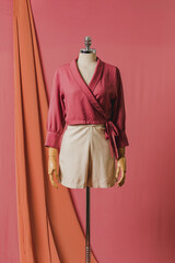 mannequin in a dress on a mannequin red pink background fashion still photography blouse skirt