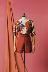 mannequin in a dress on a mannequin red pink background fashion still photography blouse skirt