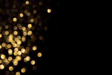 Golden blurred bokeh lights on black background. Glitter sparkle stars for celebrate. Overlay for...