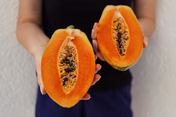 Woman hands holding orange, juicy, tasty, fresh, sliced mangoes on white wall background