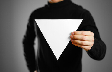 Man showing blank triangular white paper. Leaflet presentation. Pamphlet hold hands. Man show clear...