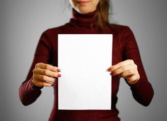 Woman showing blank white flyer paper. Leaflet presentation. Pamphlet hold hands. Girl show clear...