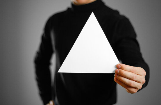 Man showing blank triangular white paper. Leaflet presentation. Pamphlet hold hands. Man show clear offset paper. Sheet template