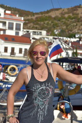 woman in summer in a T-shirt and shorts on the mooring of boats