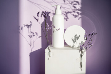 Jars of cosmetics on a purple background with lavender.