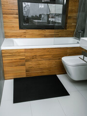 A rubber mat on the floor next to the bathtub in the bathroom. Interior design, modern bath - 488566201