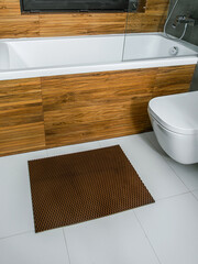 A rubber mat on the floor next to the bathtub in the bathroom. Interior design, modern bath - 488566205
