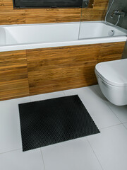 A rubber mat on the floor next to the bathtub in the bathroom. Interior design, modern bath - 488566219