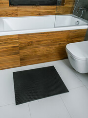 A rubber mat on the floor next to the bathtub in the bathroom. Interior design, modern bath - 488566220
