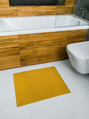 A rubber mat on the floor next to the bathtub in the bathroom. Interior design, modern bath - 488566241