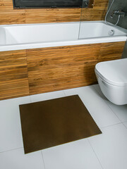 A rubber mat on the floor next to the bathtub in the bathroom. Interior design, modern bath - 488566243