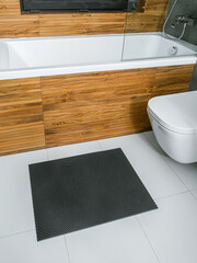 A rubber mat on the floor next to the bathtub in the bathroom. Interior design, modern bath - 488566279