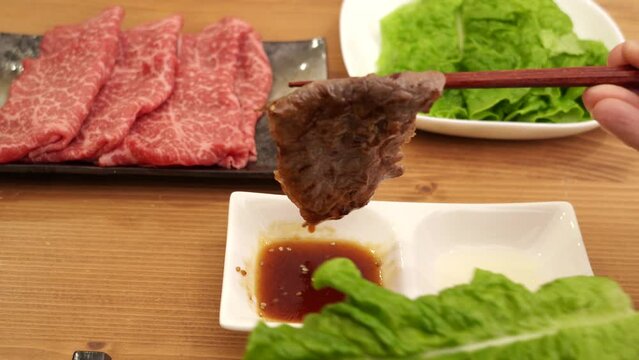 国産和牛の焼肉をタレにつける手元