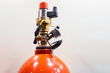Fragment of red extinguisher. Fire extinguisher head close up. Gas fire extinguishing module with...