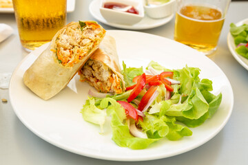 chicken and fish wrap with fresh green mixed salad.