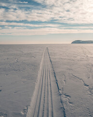 the snowmobile left behind a long strip in the snow	