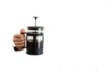 Hand holding black french press with tea on white background