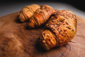 three Freshly baked croissant on a wooden Tray. Delicious and healthy breakfast