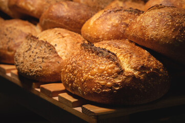 Sourdough bread close-up. Freshly baked round bread with golden crust on bakery shelves. The context of a German bakery with a rustic assortment of bread.