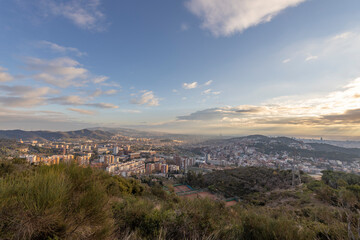 Panorama of Barcelona from the air in the early morning. City with shadows from the clouds. Dramatic sky over the city. Autumn in Barcelona, Spain.