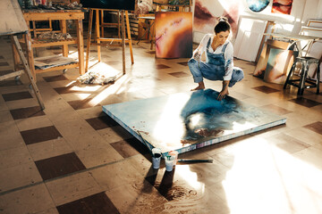 Female painter working on a new painting in her atelier