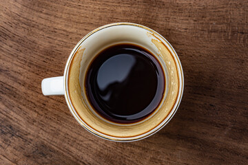 cup of coffee on wooden background top view close-up