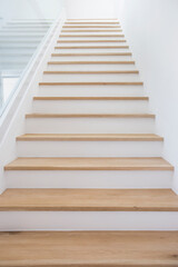 Wooden stairs with clean white walls.