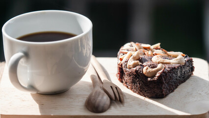 Black coffee and a brownie cake on a wooden table, Placed on a wooden table.