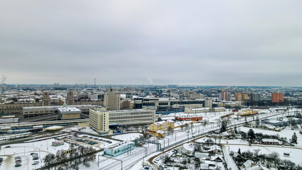 Beautiful top view of cityscape with tv tower, ferris wheels, factory and buildings in winter.