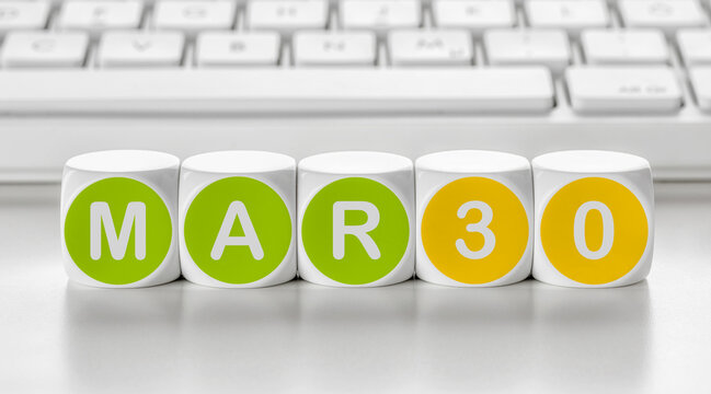 Letter dice in front of a keyboard - March 30