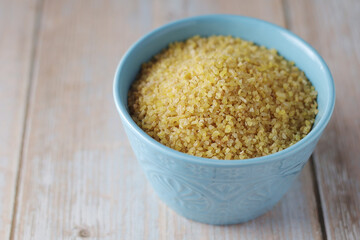 Dry uncooked bulgur in a ceramic bowl